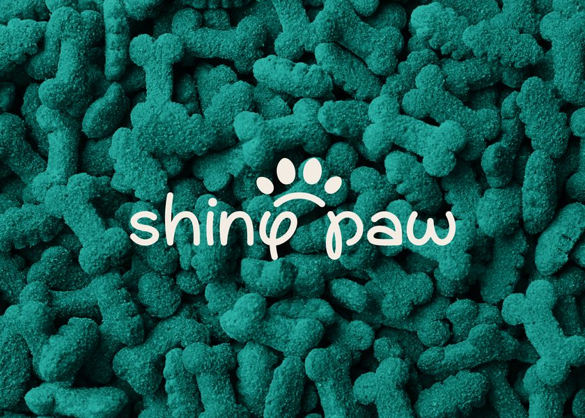 Il logo Shiny Paw bianco su crocchette verde acqua